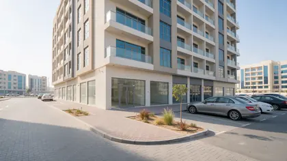 Building with ground-floor shops and street parking on the approach to Chameli Spa