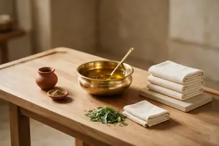 Brass bowl, clay pot, herbs and folded towels on a wooden table