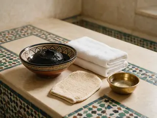 Black soap bowl, kessa glove and towels on Moroccan tiles